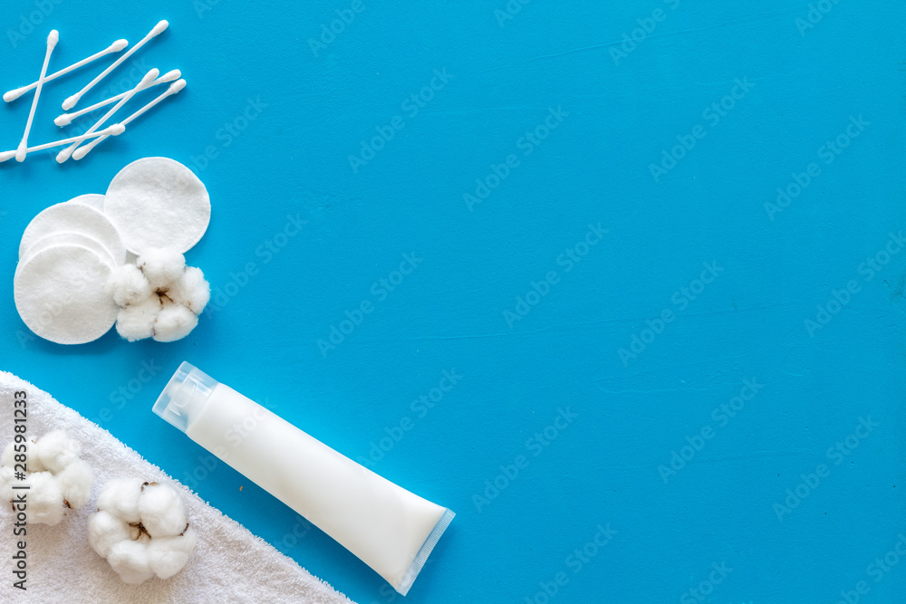 Hygiene cotton swabs, pads and cream for pattern on blue background top view mockup Hygiene cotton swabs, pads and cream for pattern on blue background top view mockup