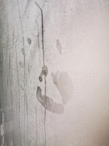 hand print on the wet shower glass