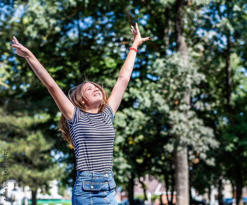 Happy caucasian woman in casual clothes smiling and having fun in the park in summer sunny day