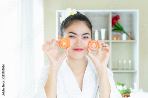 Young Asian woman enjoyment treatment spa with tomato in beauty salon