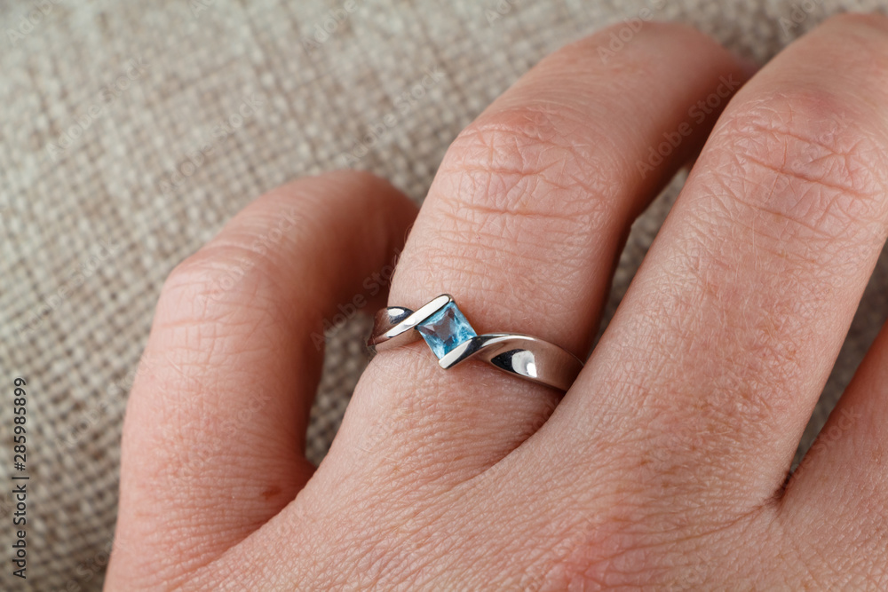 Ring made with white gold and aquamarine on the hand of a woman Ring made with white gold and aquamarine on the hand of a woman