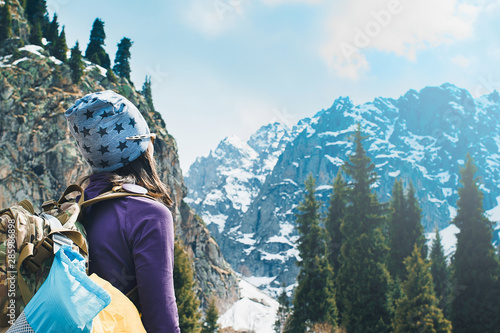 Traveling girl with backpack hiking in the mountains, freedom concept. Hiking people on Asia. Beautiful young woman traveler with a backpack looks at the mountain top before climbing