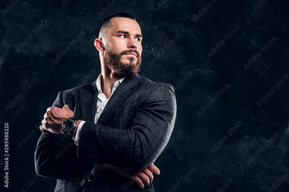 Handsome sucessful buisnessman is posing for photographer on the dark background. Handsome sucessful buisnessman is posing for photographer on the dark background.