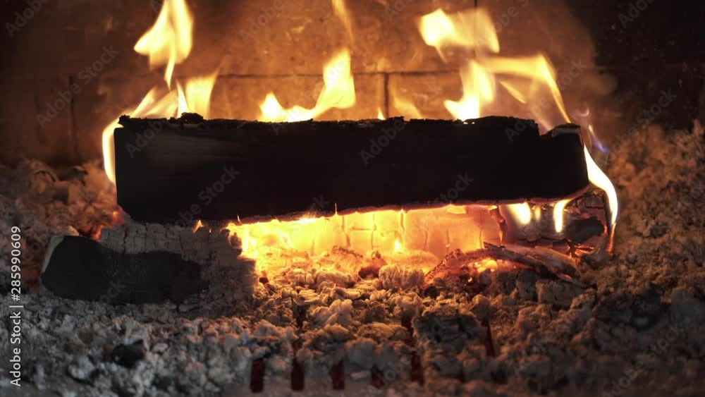 Looping video of wood burning inside a fireplace. Fire playing around ...