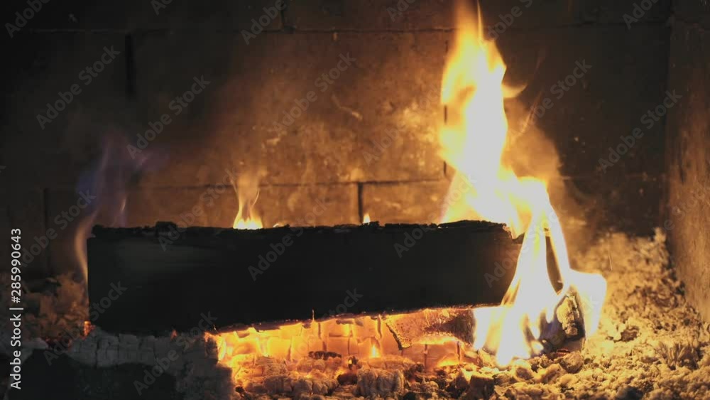 Looping video of wood burning inside a fireplace. Fire playing around