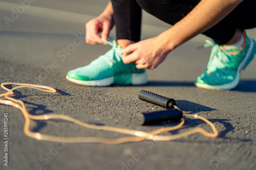 Foto Fitness woman is tying shoelaces on sneakers and is preparing to do cardio exerc