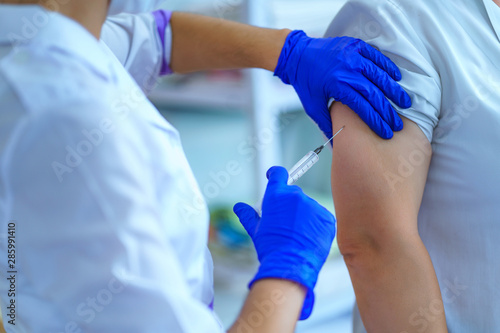 Nurse vaccinated patient against flu and measles during an epidemic. Flu shot, protection and prevention of viral infectious diseases