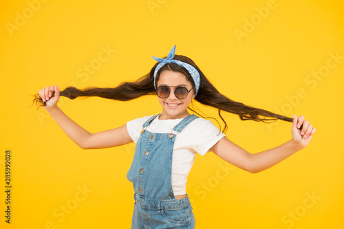 Strong hair. Cute kid fashion girl. Summer fashion concept. Girl long curly hair sunglasses tied head scarf. Fashion trend. You can have anything you want if dress for it. Little fashionista