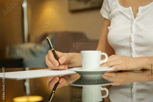 Woman writing on a white sheet of paper © triocean