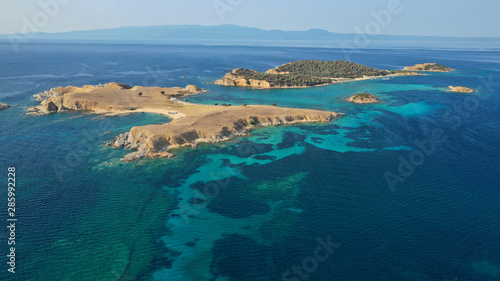 Aerial drone view of paradise small secluded island complex of Drenia and Pena with turquoise and sapphire sea near famous Amouliani island in North Greece, Halkidiki