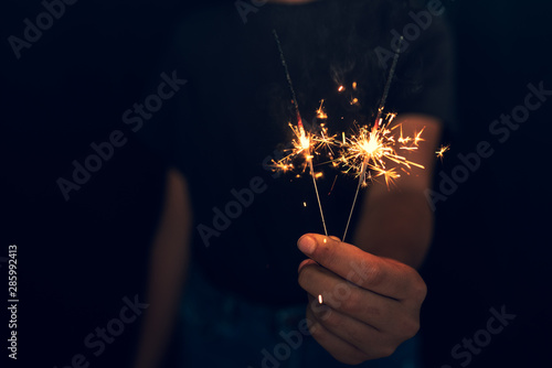 young girl burning sparkler in hand