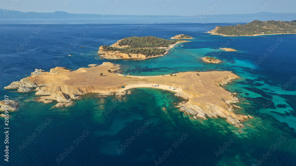 Aerial drone view of paradise small secluded island complex of Drenia and Pena with turquoise and sapphire sea near famous Amouliani island in North Greece, Halkidiki