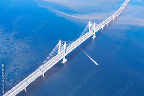 Obraz na płótnie Speed ship passing under large cable stayed bridge aerial view w salonie