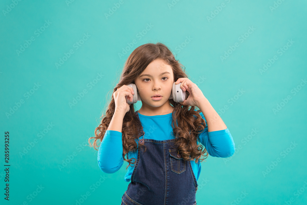 Everything but music. Little girl enjoying her favorite music on blue background. Small child listening to music. Adorable kid wearing stylish headphones playing music Everything but music. Little girl enjoying her favorite music on blue background. Small child listening to music. Adorable kid wearing stylish headphones playing music