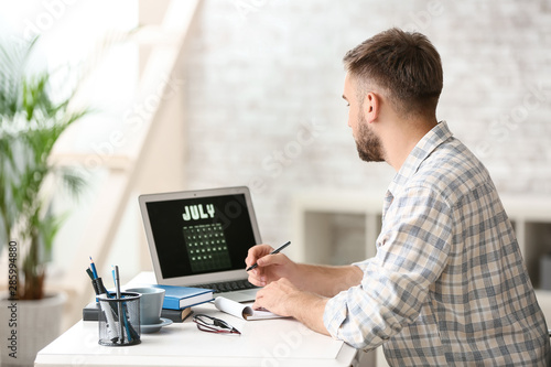 Man using calendar on lapto...