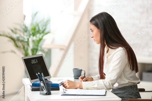 Woman using calendar on lap...