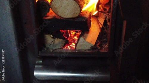Burning logs in sauna stove. Slow motion.