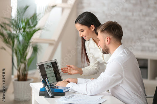 Office workers using calend...