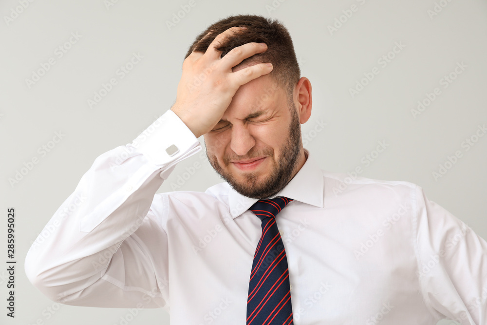 Businessman having panic attack on light background Businessman having panic attack on light background