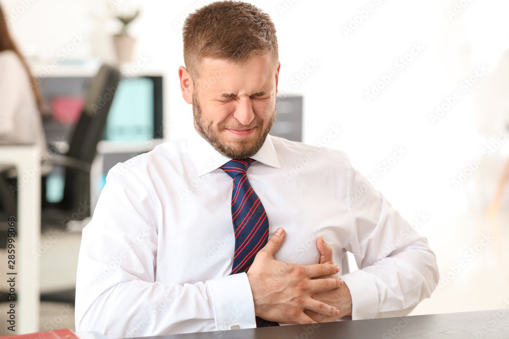 Businessman having panic attack in office Businessman having panic attack in office