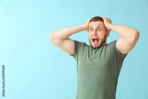 Man having panic attack on color background