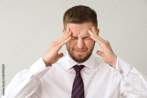 Businessman having panic attack on light background