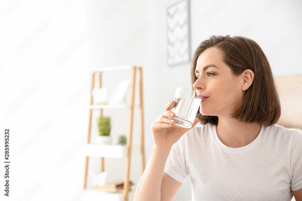 Morning of beautiful young woman drinking water in bedroom Morning of beautiful young woman drinking water in bedroom