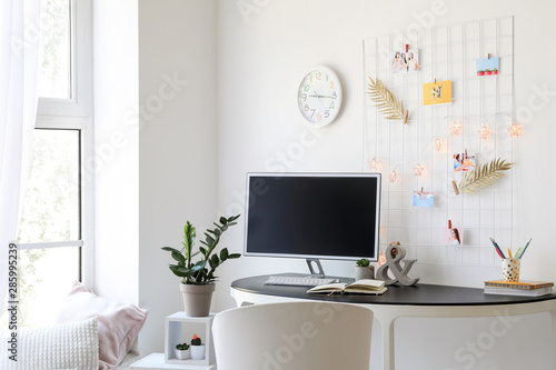Workplace with mood board and computer in modern room © Pixel-Shot