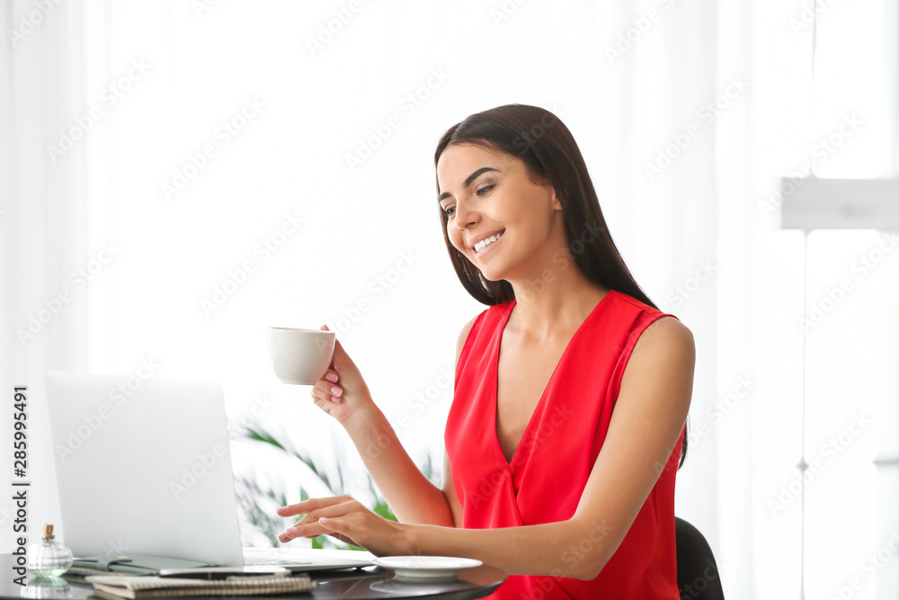 Female blogger with laptop drinking coffee in cafe Female blogger with laptop drinking coffee in cafe