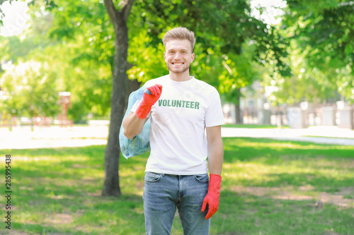 Male volunteer gathering garbage in park