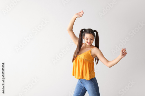 Dancing young woman on ligh...
