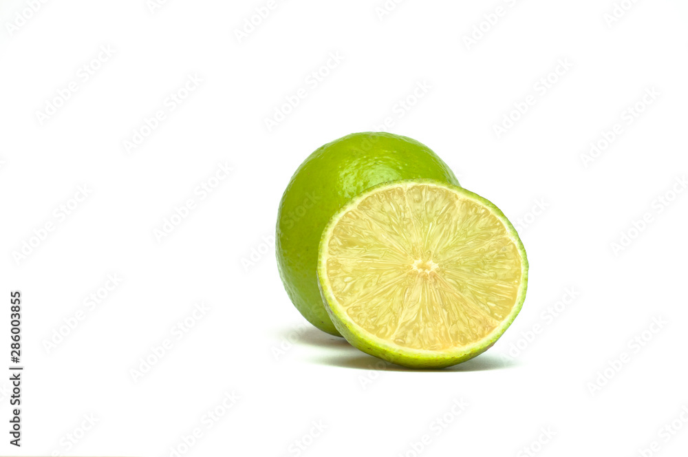 whole and half with slice of fresh green lime on white background