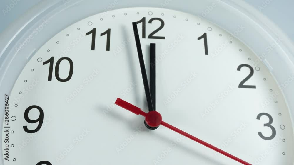 Closeup Zoom out Twelve o'clock White wall clock face beginning of time 11.45 am Eat lunch, Time lapse 20 minutes moving fast. Closeup Zoom out Twelve o'clock White wall clock face beginning of time 11.45 am Eat lunch, Time lapse 20 minutes moving fast.
