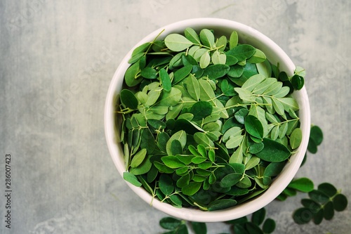 Fresh Moringa or muringa leaves ina bowl, selective focus photo