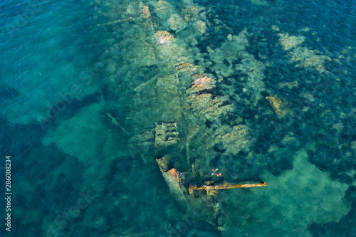 View from above, stunning aerial view of a wreck inside the Marine Protected Area of Tavolara. Some people snorkel in an emerald green sea. Sardinia, Italy. photo