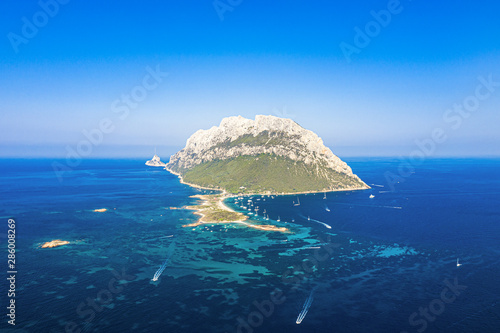 View from above, stunning aerial view of the beautiful Tavolara Island with its beach bathed by a turquoise clear sea. Tavolara is a small island off the northeast coast of Sardinia, Italy. photo