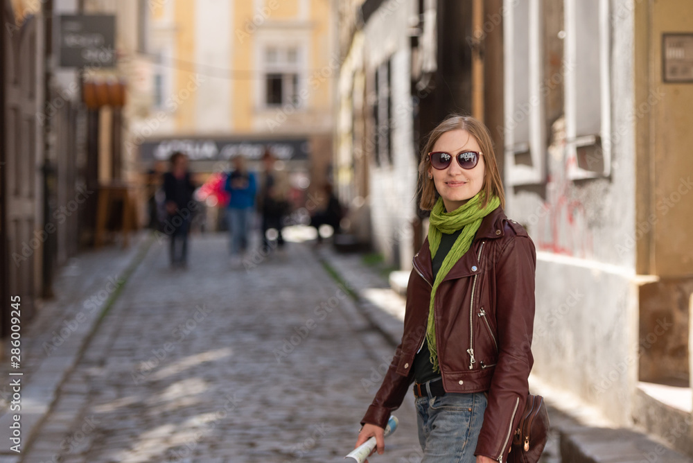 Girl with city map. Walk through Bratislava. Leather jacket and sunglasses. On the old street.