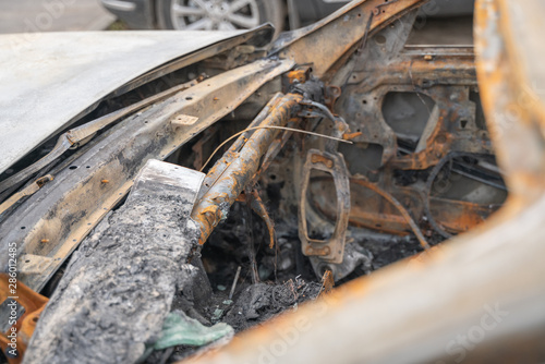 crushed melt car after deliberate arson. destroyed vehicle after a fire melted is on the street.