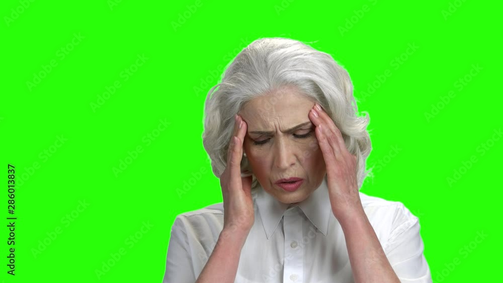 Mature woman having severe headache. Frustrated senior lady feeling strong headache on green screen background. High blood pressure symptoms. Mature woman having severe headache. Frustrated senior lady feeling strong headache on green screen background. High blood pressure symptoms.