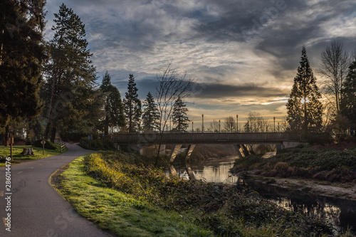 Sunrise on the Sammamish river with a bridge over the river and the paved trail on the left in Redmond Washington