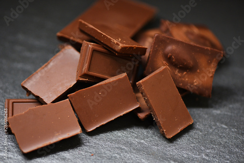 Chocolate bar stacked on the dark background - close up chocolate pieces candy sweet dessert and snack