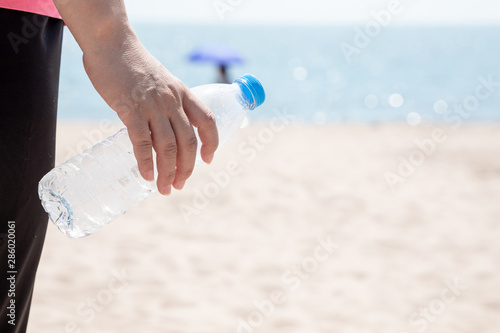 Woman holding empty plastic bottle