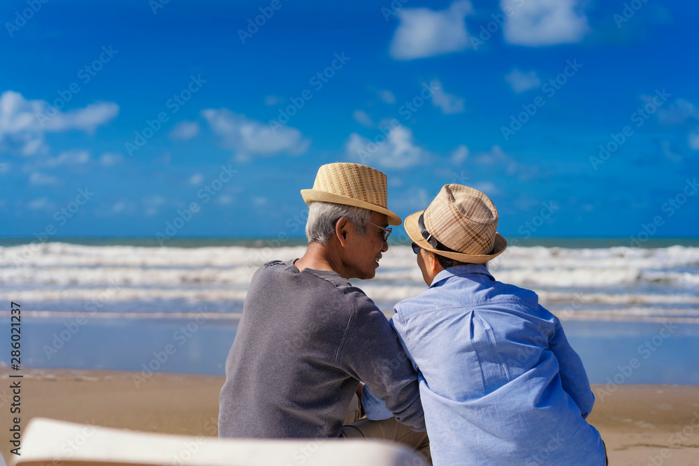 Senior couple sitting on chairs on the beach and looking at the ocean in a romantic,Elderly life insurance,Men take care of each other when aging.