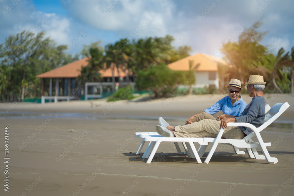 Senior couple sitting on chairs on the beach and looking at the ocean in a romantic,Elderly life insurance,Men take care of each other when aging.