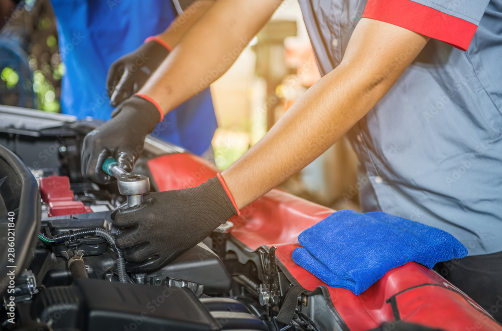 Close-up hand off mechanic working on car engine in mechanics garage. Repair service. Close-up hand off mechanic working on car engine in mechanics garage. Repair service.