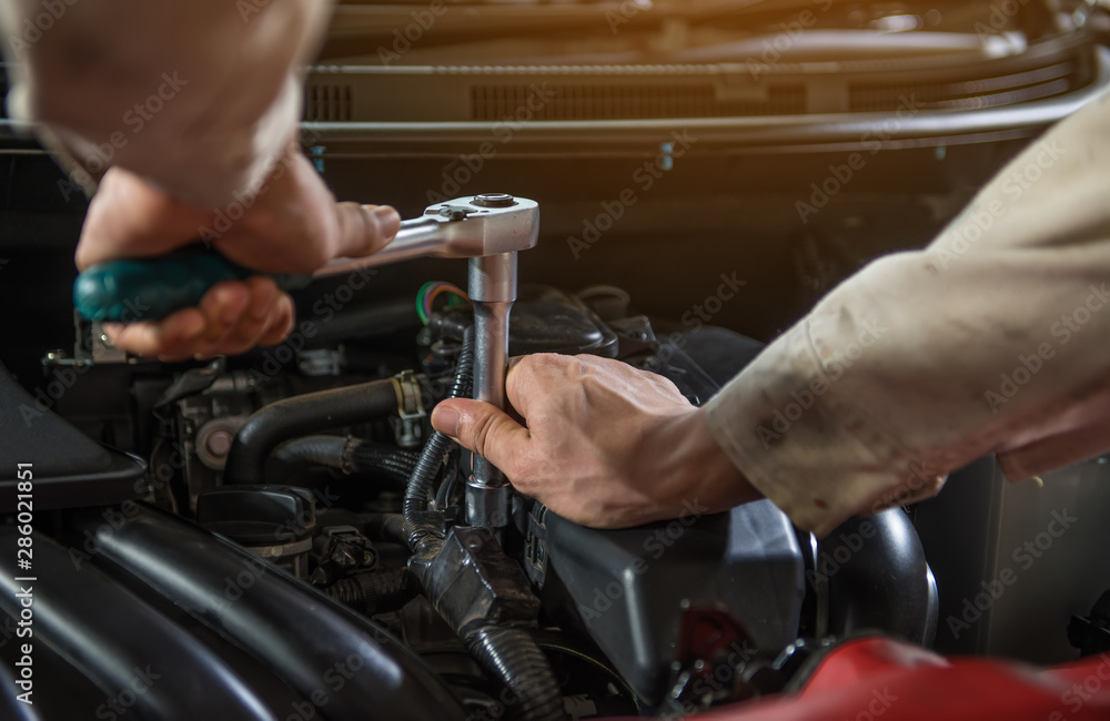Close-up hand off mechanic working on car engine in mechanics garage. Repair service. Close-up hand off mechanic working on car engine in mechanics garage. Repair service.