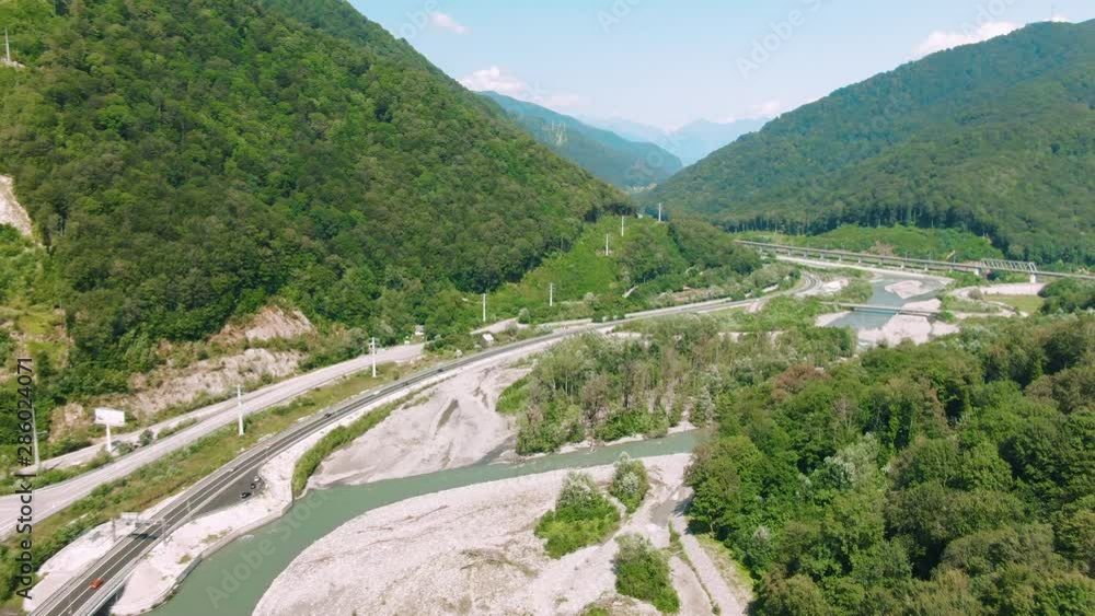 Aerial 4k view. Straight down aerial shot on bridge or raised up road connecting two sides of lake or bay through beautiful blue water. Concept logistics and transportation. Cars on travel road trip Aerial 4k view. Straight down aerial shot on bridge or raised up road connecting two sides of lake or bay through beautiful blue water. Concept logistics and transportation. Cars on travel road trip
