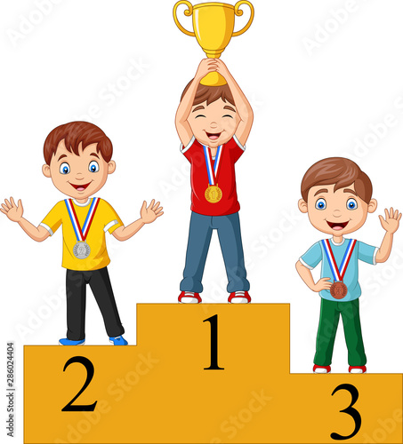 Children with medals standing on podium and holding a trophy