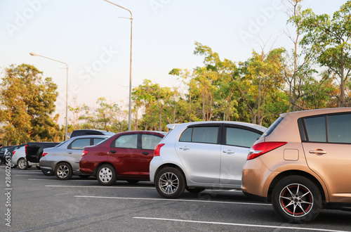 Closeup of rear or back side of pink-gold  car with  other cars parking in outdoor parking lot with natural background in twilight evening.  © Amphon