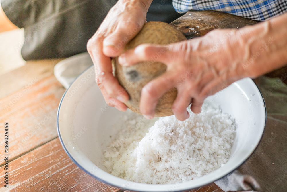 The cook's hand is scraping the coconut The cook's hand is scraping the coconut
